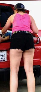 Girl showing her ass cheeks at her car in black shorts