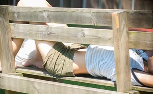 Girl in Shorts and a Top Lying on a Bench Hot Photo