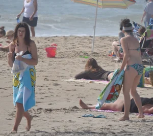 Bikini girls setting up for a day on the beach in their bikinis
