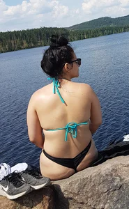 Thick brunette at the lake in a black thong bikini
