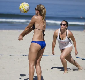 Hot girls playing beach volleyball in bikinis and shorts