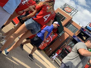 Bunch of girls in various outfits at a Cardinals baseball game