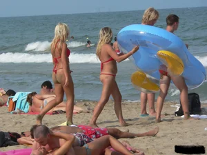 Sexy mom and daughter in red thongs at the beach