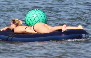 Black thong bikini blonde with a nice ass out on a tube in the water