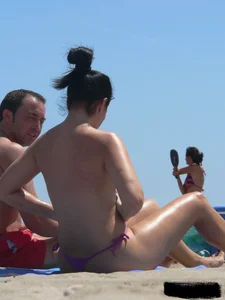 Purple thong topless lady on the beach gets oiled up by her husband