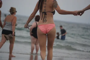 Peach bikini tattood babe on the beach with a nice ass and some camel toe