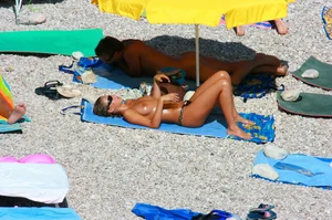 Nudist couple on the beach, girl has amazing tits and nice ass in a thong
