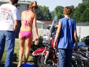 Group of cute girls at a car wash in bikinis and shorts