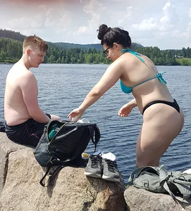 Thick brunette at the lake in a black thong bikini