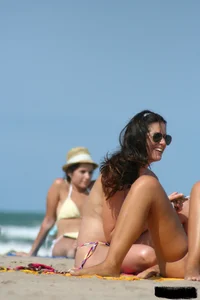 2 topless girls at the beach in thongs