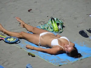 Sexy beach girl laying out in white bikini with nice body