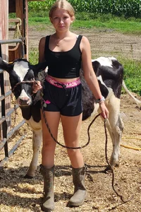 Very cute non-candid blonde teen with a cow