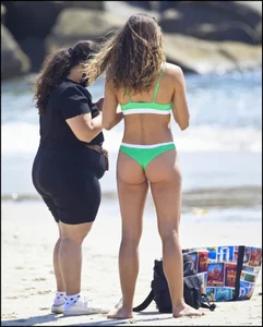 Super hot beach babe with a perfect body in a green thong bikini