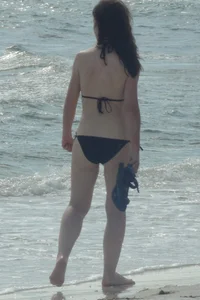 Lady on the beach in black bikini with nice ass