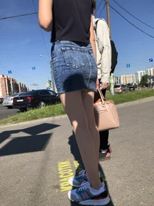 Cute Girl in a Short Denim Skirt Walking on a Street And Waiting on a Crosswalk Gallery