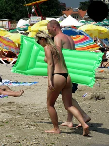 Topless blonde babe on the beach with a big booty in a black thong