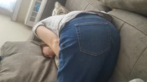 Girl in Blue Jeans Curled Up Asleep on the Couch
