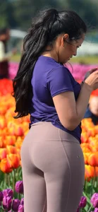 Cute babe in tight leggings taking pictures in flower fields