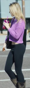 Beautiful skinny blonde in tight leggings and purple crop top showing sexy stomach