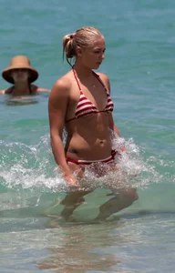 Blonde looking sexy on the beach in red striped bikini