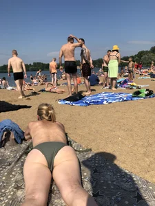 Gorgeous milf rubbing sun lotion in her skin at the beach, with a couple of her milf friends