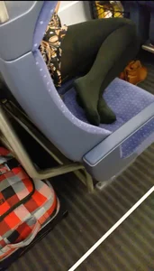 Girl in a Dress And Black Pantyhose Sitting With Her Feet on the Seat in the Train Creepshot