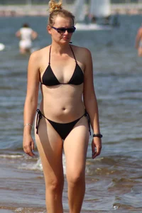 Strawberry blonde sexy mature girl walking the beach in black bikini
