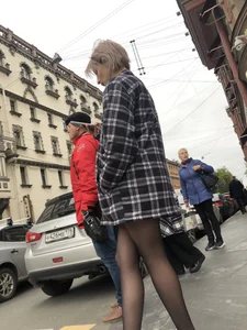 Cute candid girl with legs in black pantyhose waiting on the crosswalk