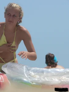 Sexy blonde on the beach in a yellow thong bikini