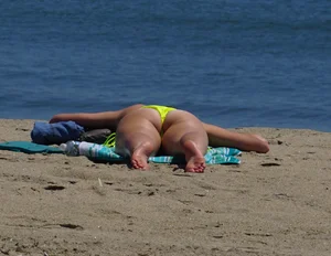 Sexy ass blonde milf on the beach in a thong with cameltoe and bending over