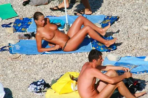 Nudist couple on the beach, girl has amazing tits and nice ass in a thong