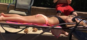 Blonde at the pool and laying out in peach and black bikini combo