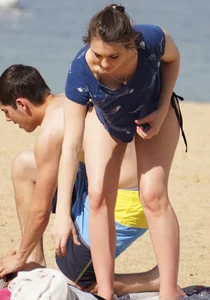 Sexy girl on the beach laying out and bending over in her bikini