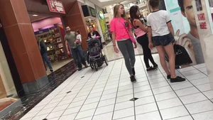 Little blonde teen in grey leggings at the mall with her friends
