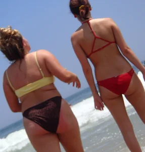 Thick girl and her skinny friend in bikinis at the beach