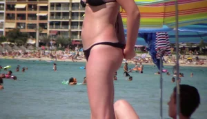 Amazing ass in semi-thong bikini on the beach with tanlines