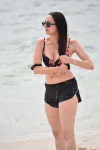 Brunette girl in black shorts and bikini top on the beach