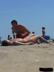Purple thong topless lady on the beach gets oiled up by her husband