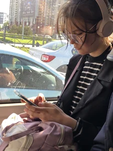 A Very Cute And Skinny Candid Teen Girl Wearing Glasses, A Skirt And Knee Socks Sitting in a Public Bus, Closeups of Her Legs
