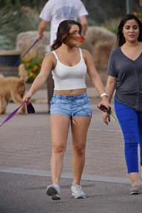 Sexy dog walker in shorts and tank top with friend in blue jeans