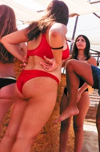 Thick brunette on the beach with friends in red bikini