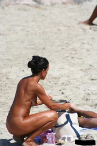 Smoking milf at a nude beach with a hairy pussy
