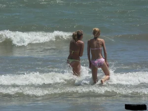 Sexy blonde on the beach in a yellow thong bikini