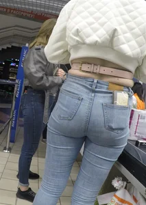 Two hot milfs in tight blue jeans standing at the cash register at the supermarket, awesome big butts