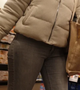 Girl with a tight ass in grey jeans going up the escalator