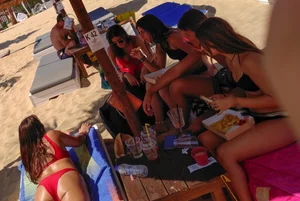 Thick brunette on the beach with friends in red bikini