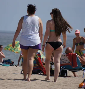 Sexy beach brunette in teal top and black bottom bikini