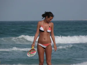 Skinny and sexy lady in a bikini playing on the beach