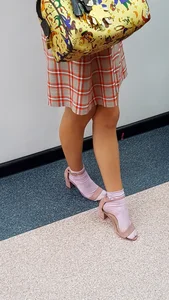 Girl in a Skirt and Sandals on Heels in White Socks with Nice Legs Closeup Creepshot