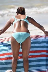 Tanned brunette girl on the beach in a bikini